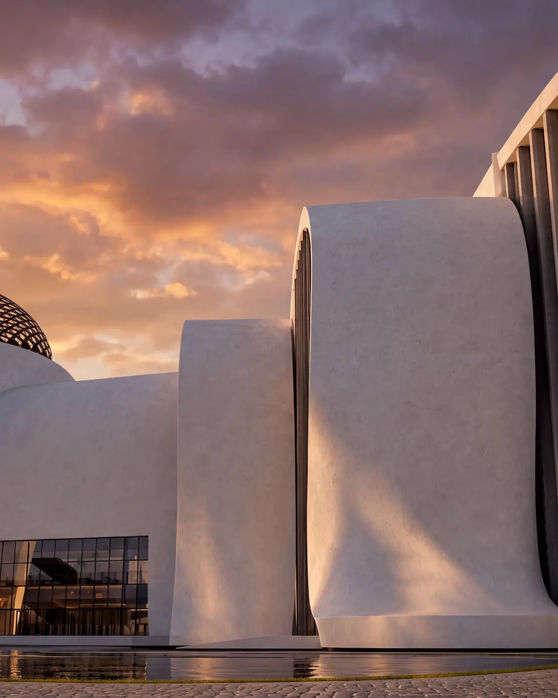 Close view of a glazed dome and sweeping white walls glowing under a sunset sky.
